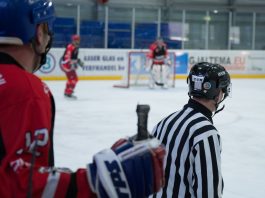 An Ice Hockey Player Standing behind the Referee in the Stadium