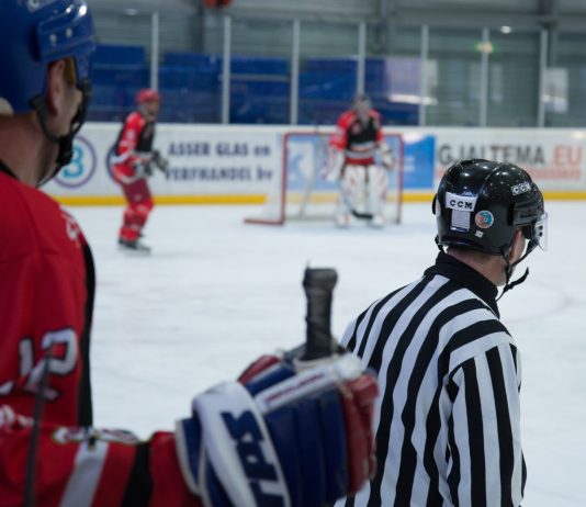An Ice Hockey Player Standing behind the Referee in the Stadium